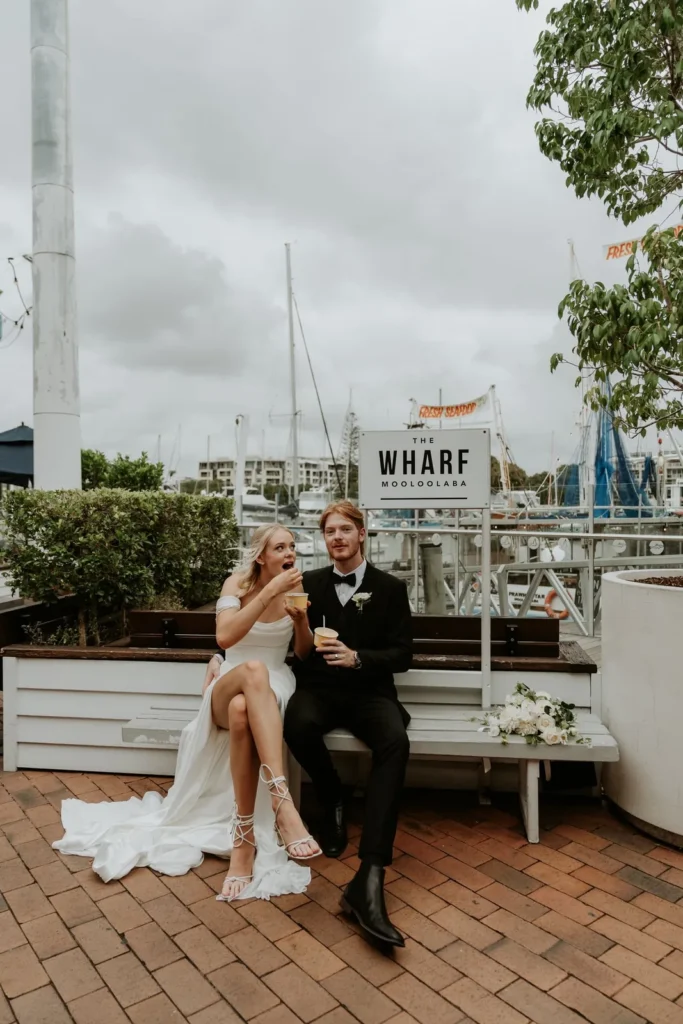 Wedding couple on the deck at The Wharf Mooloolaba with the marina behind